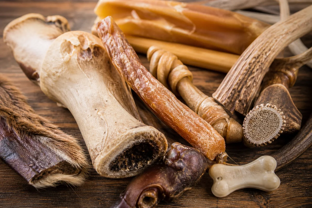 Assorted natural dog chews on wooden table